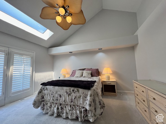 Carpeted bedroom featuring a skylight, access to outside, ceiling fan, and high vaulted ceiling