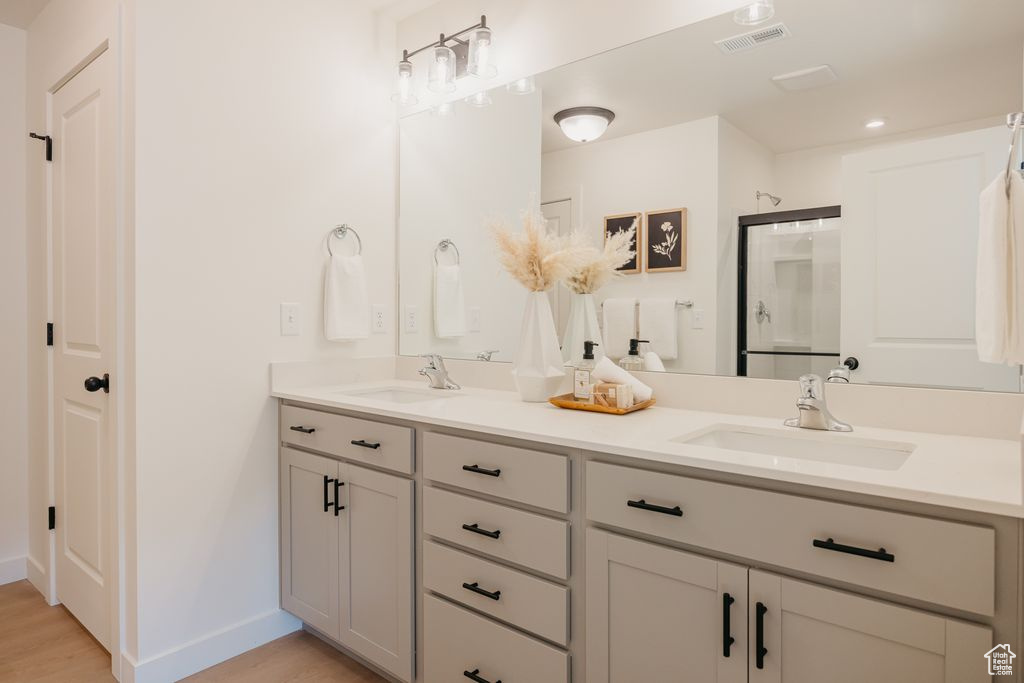 Bathroom with double vanity and wood finished floors