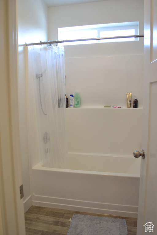 Bathroom featuring shower / bath combo with shower curtain and wood finished floors