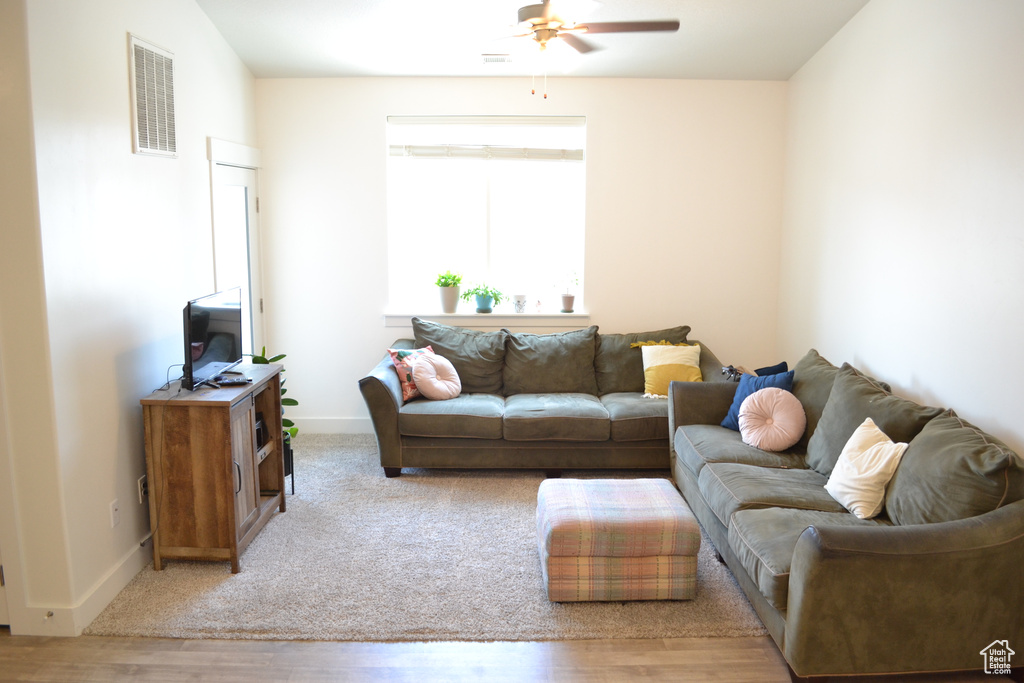 Living area with ceiling fan and wood finished floors