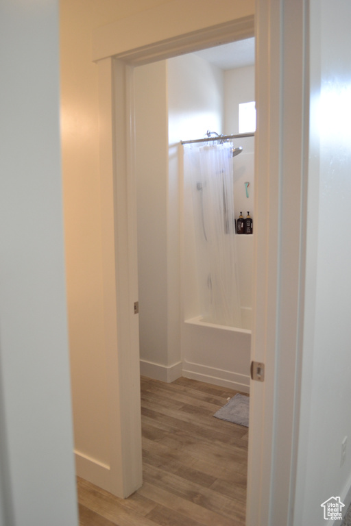 Full bath with wood finished floors and  shower combination