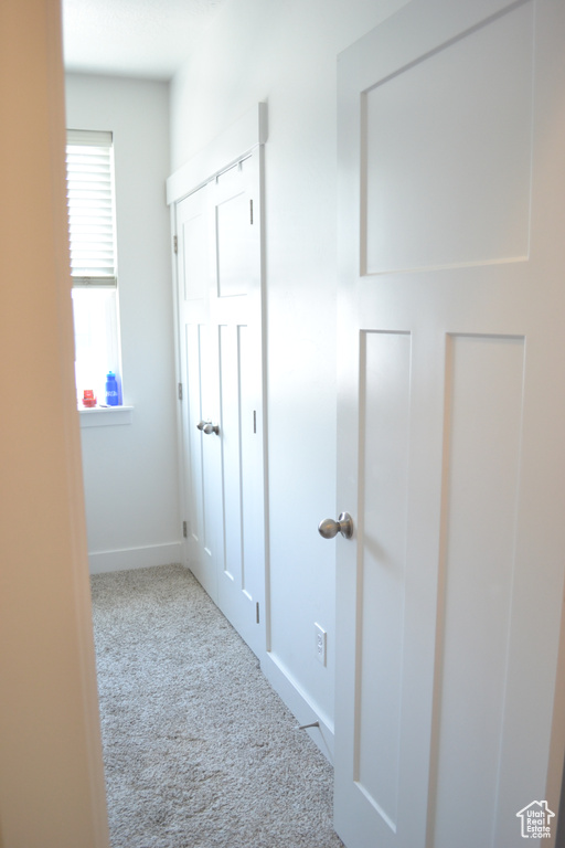 Corridor featuring carpet flooring and baseboards