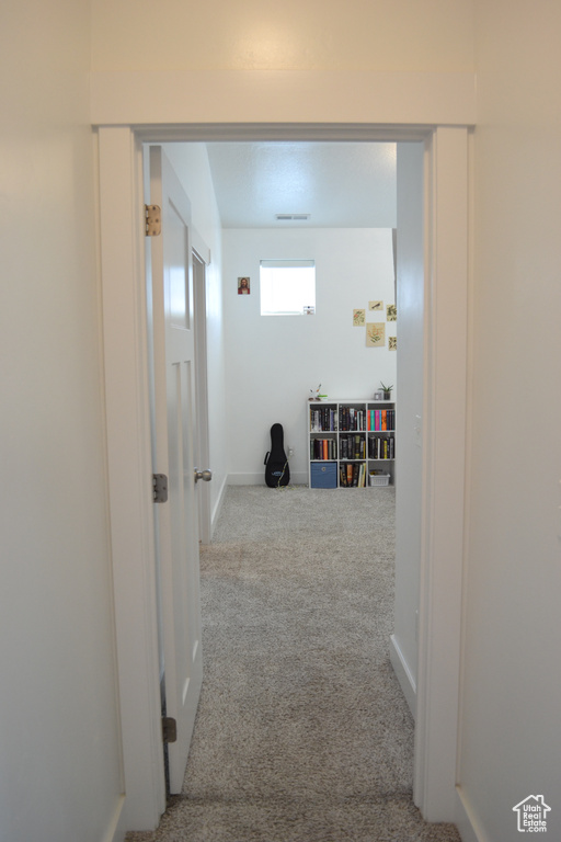 Corridor with carpet flooring and baseboards