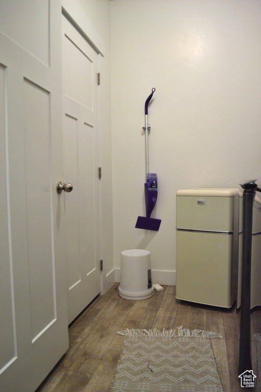 Laundry room with wood finished floors and baseboards