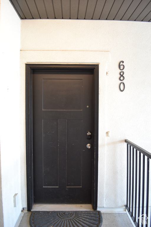 Doorway to property with stucco siding and a balcony