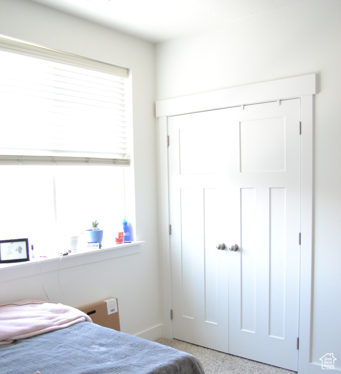 Carpeted bedroom featuring baseboards and a closet
