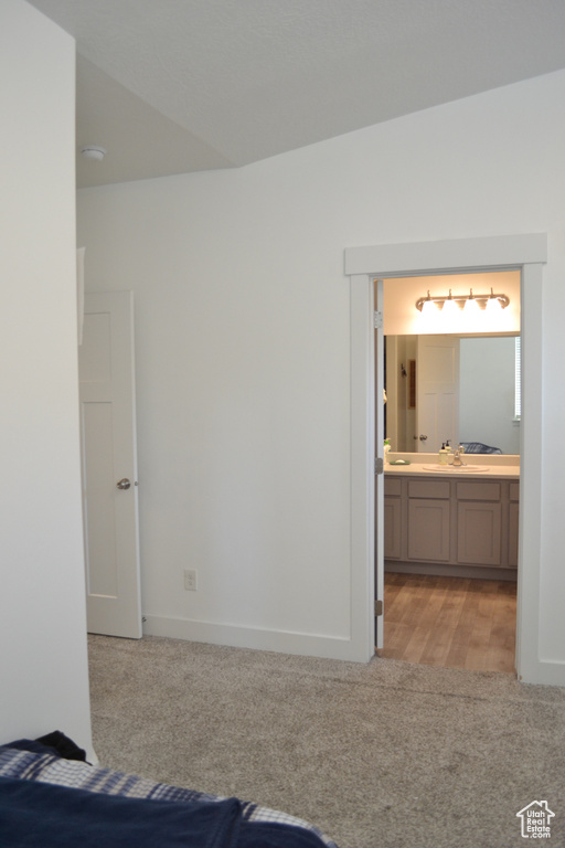Unfurnished bedroom with light colored carpet and ensuite bathroom