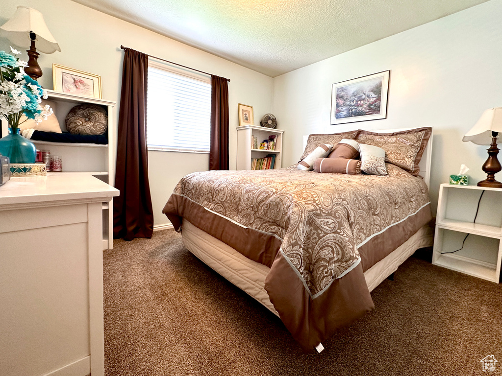 Bedroom featuring carpet and a textured ceiling