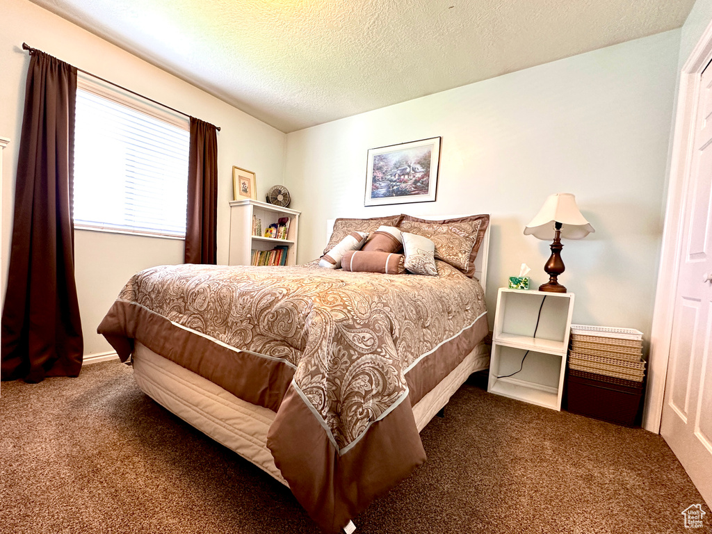 Bedroom with carpet floors and a textured ceiling