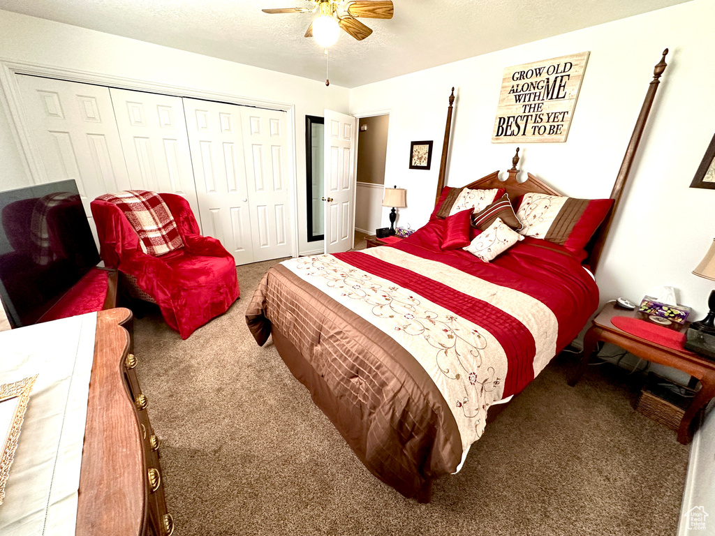 Bedroom with carpet, a closet, ceiling fan, and a textured ceiling