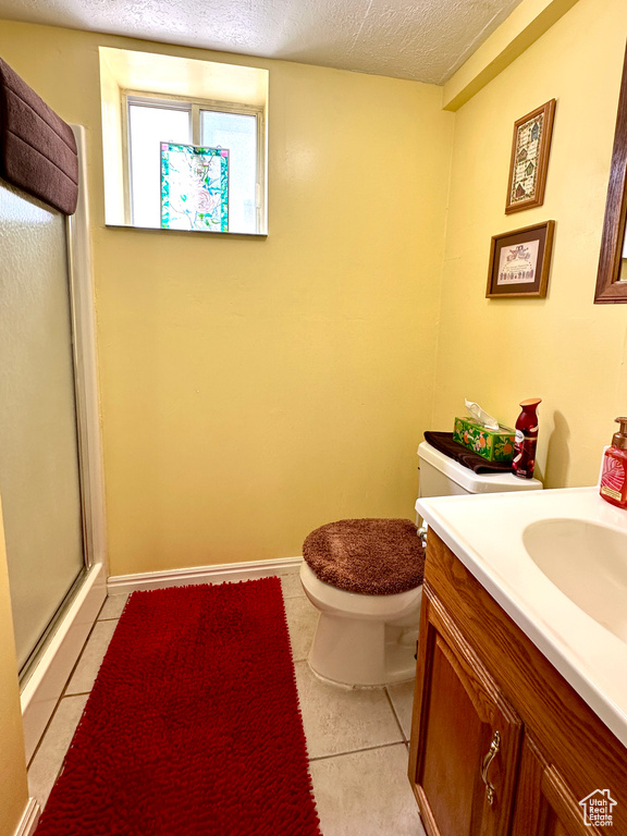 Full bath with a stall shower, tile patterned flooring, a textured ceiling, and vanity