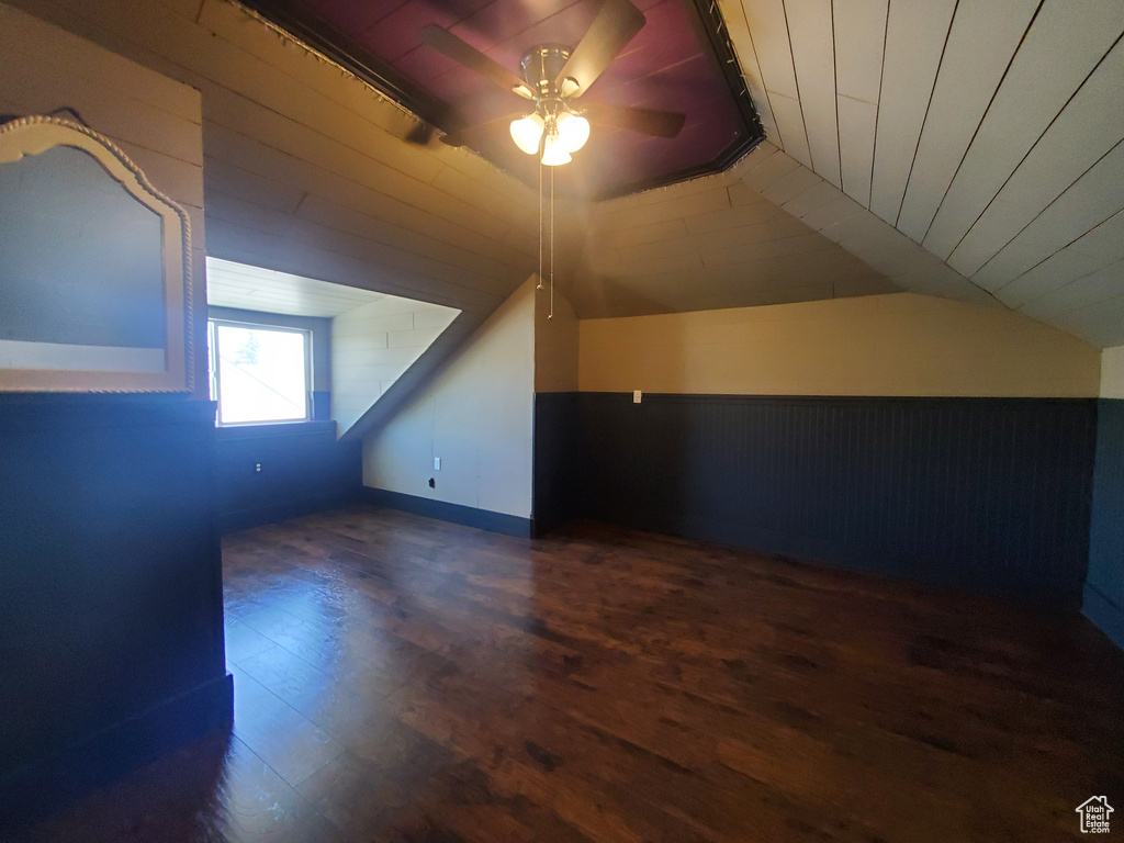 Bonus room with vaulted ceiling, ceiling fan, wood finished floors, wooden ceiling, and wooden walls