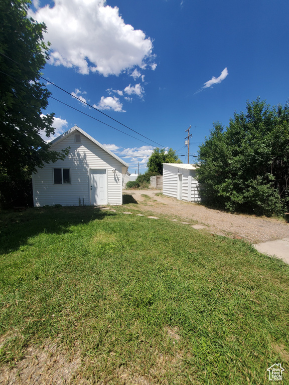 View of grassy yard featuring a shed