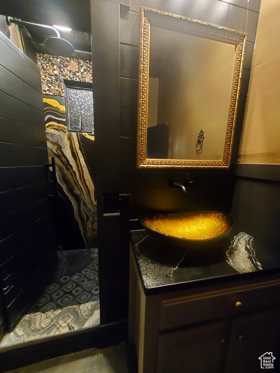 Full bath featuring vanity and a tile shower