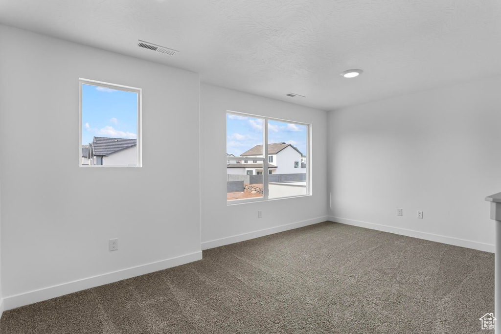 Unfurnished room with baseboards and dark carpet
