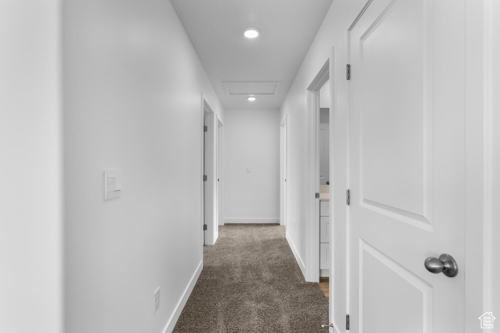 Corridor featuring dark carpet and recessed lighting
