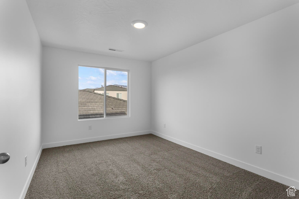 Unfurnished room featuring carpet floors and baseboards