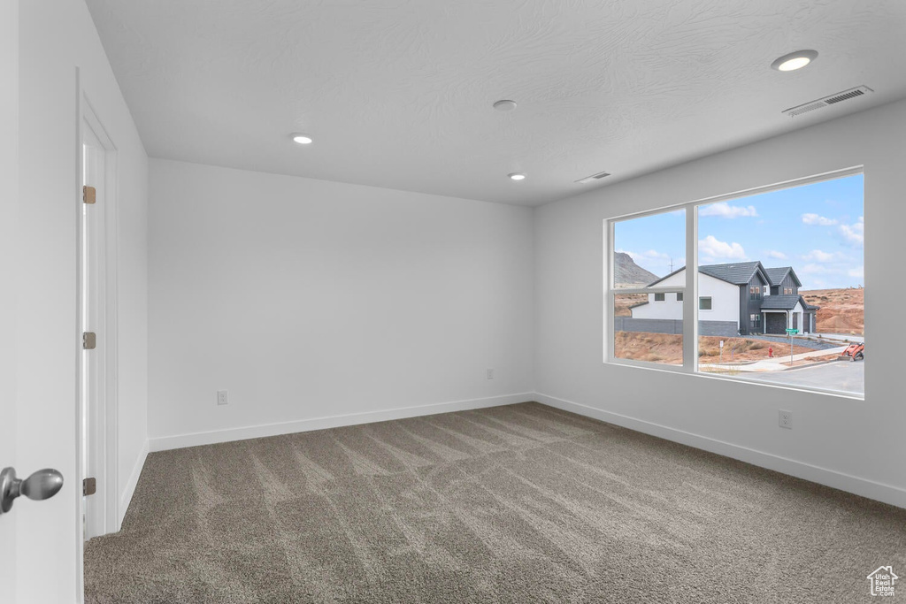 Carpeted empty room featuring baseboards and recessed lighting
