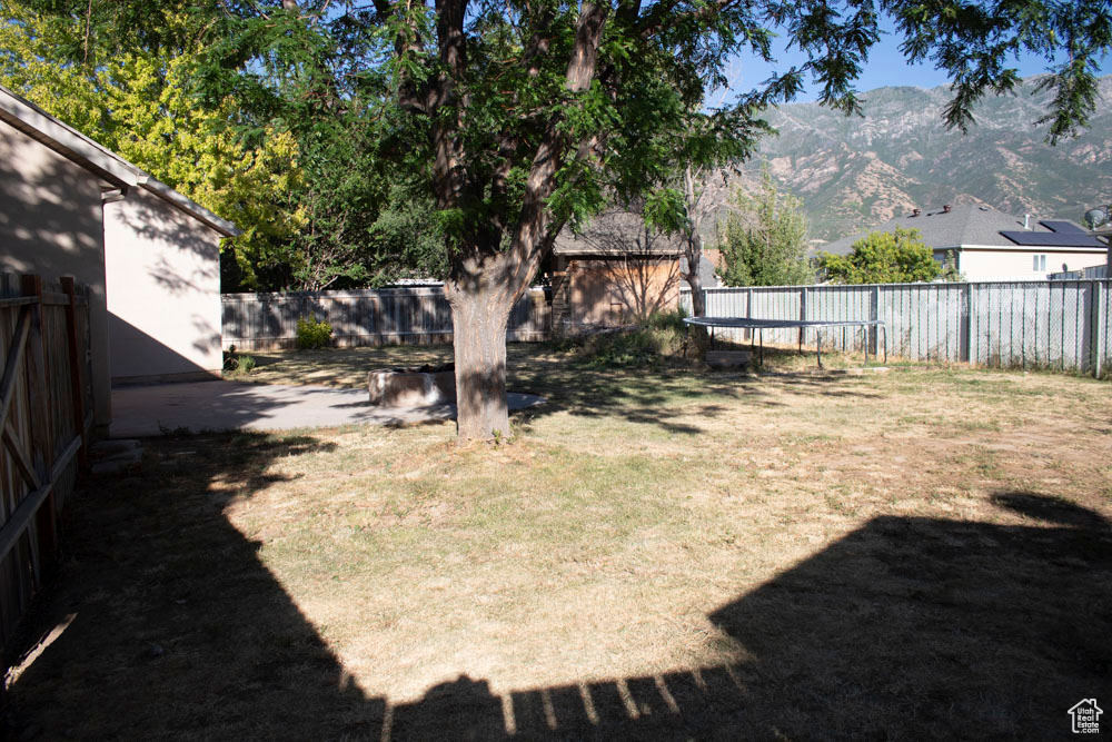 Fenced backyard featuring a mountain view
