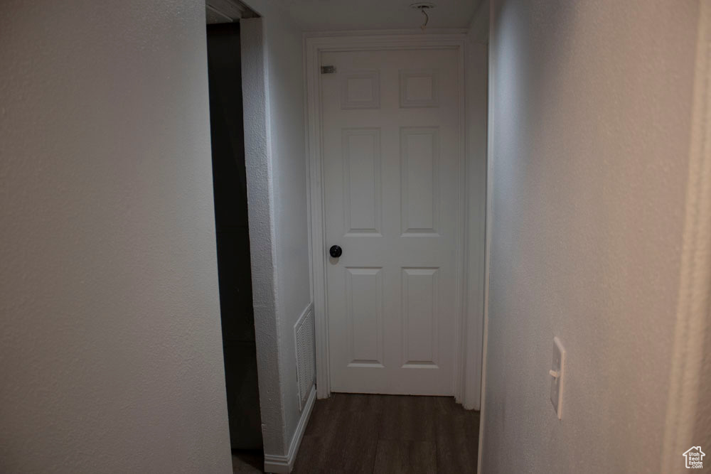 Hall with dark wood-style floors and baseboards