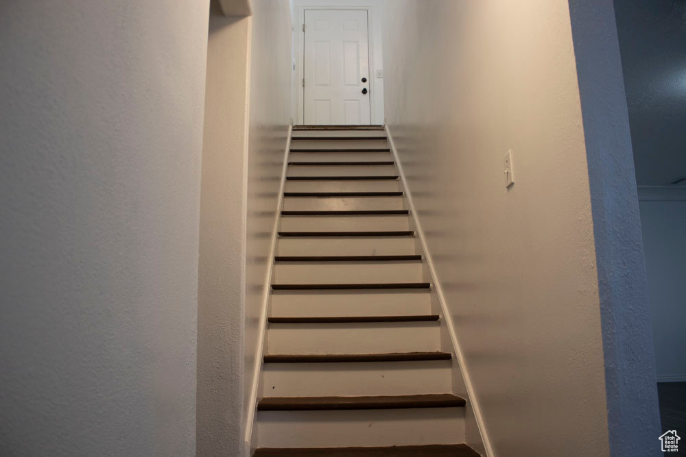 Staircase featuring a textured wall