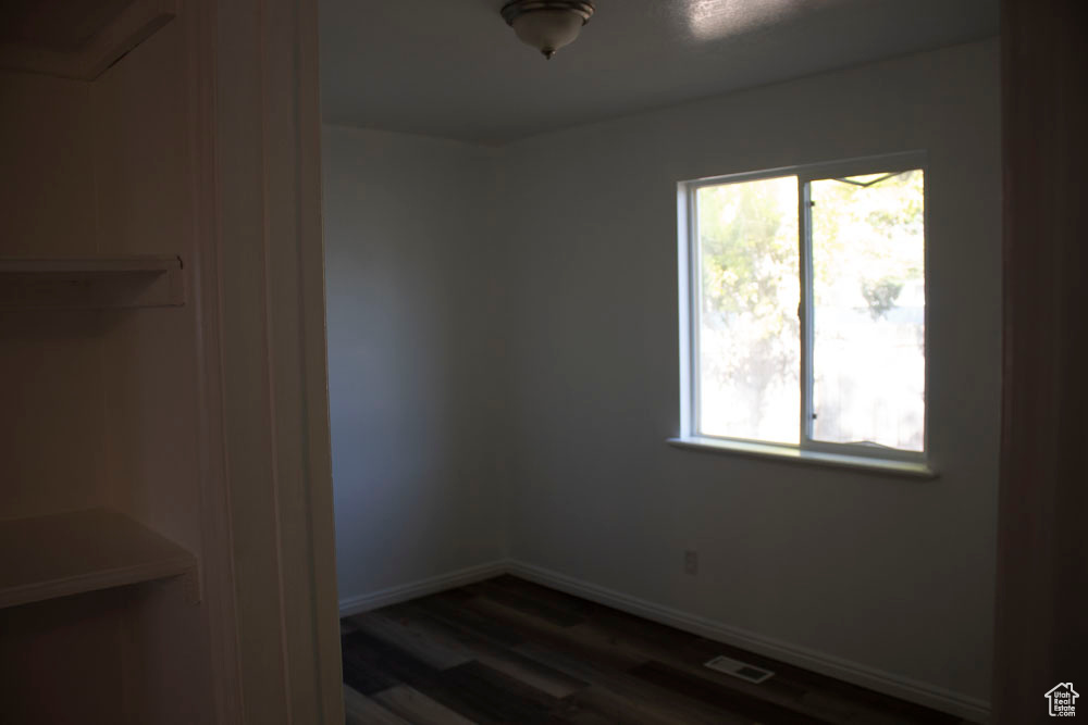 Spare room with dark wood finished floors and baseboards