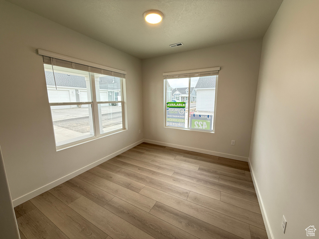 Unfurnished room featuring light wood-style floors and baseboards