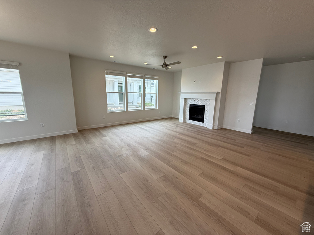 Unfurnished living room featuring recessed lighting, a ceiling fan, light wood-type flooring, and a fireplace