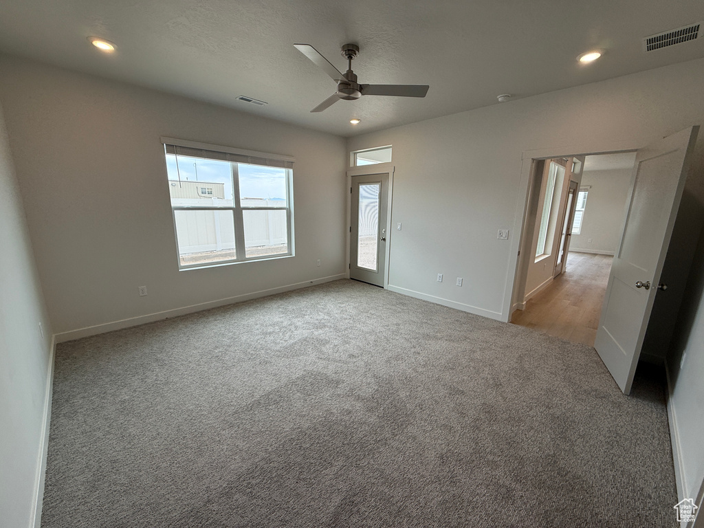 Carpeted empty room with a ceiling fan and recessed lighting