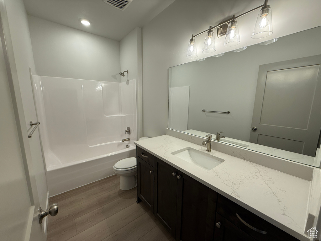 Bathroom featuring wood finished floors, vanity, bathing tub / shower combination, and recessed lighting
