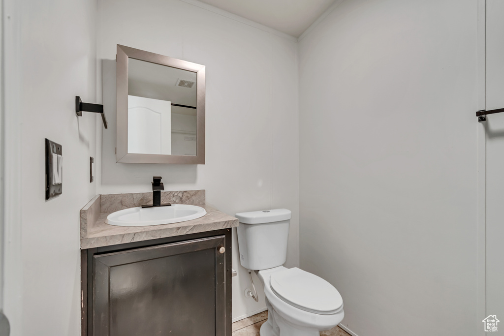 Half bathroom featuring vanity and tile patterned flooring