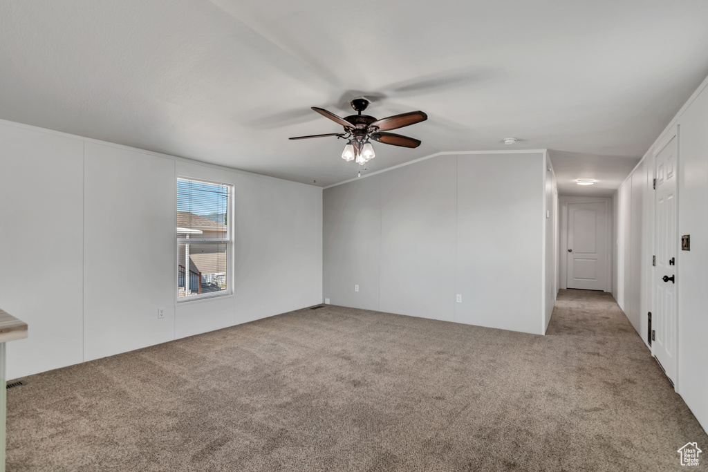 Carpeted empty room featuring ceiling fan