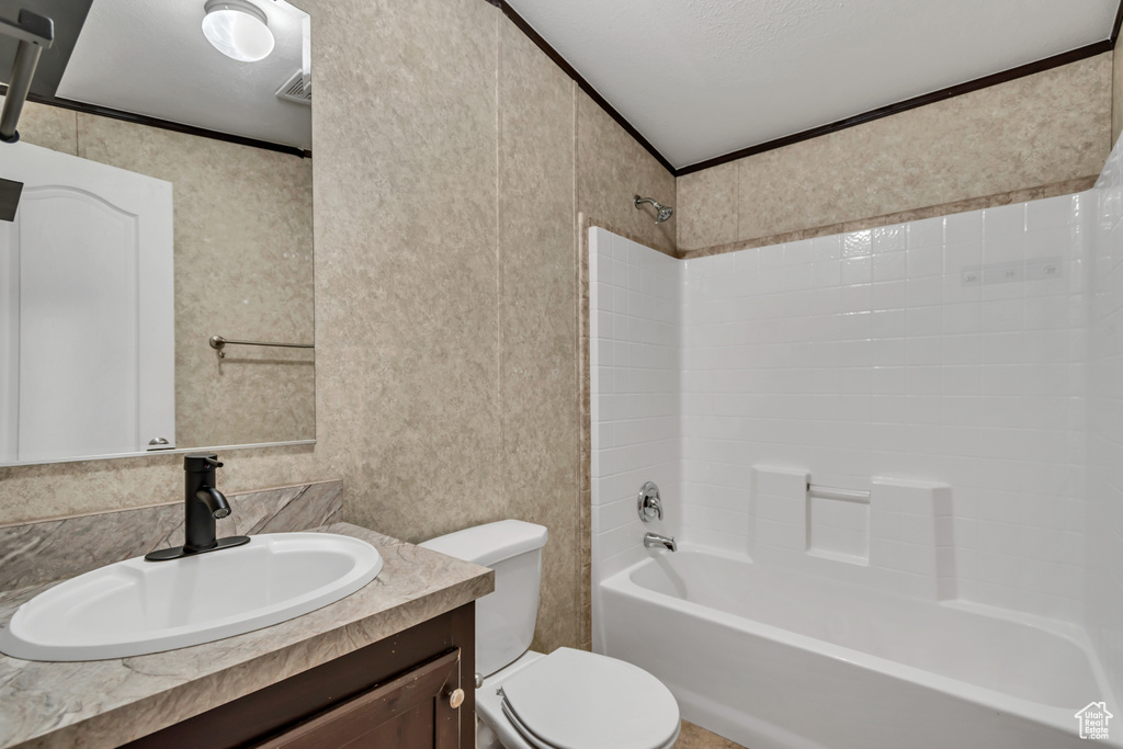 Bathroom featuring shower / washtub combination, vanity, and crown molding
