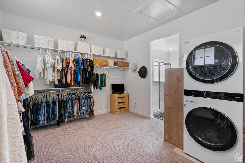 Laundry room featuring stacked washer / dryer, attic access, carpet, and recessed lighting