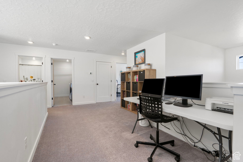 Carpeted home office with a textured ceiling and recessed lighting