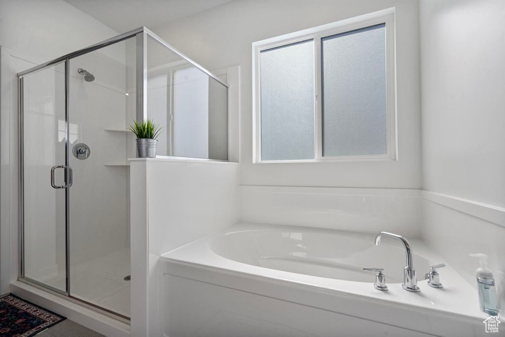 Full bathroom featuring a bath and a stall shower