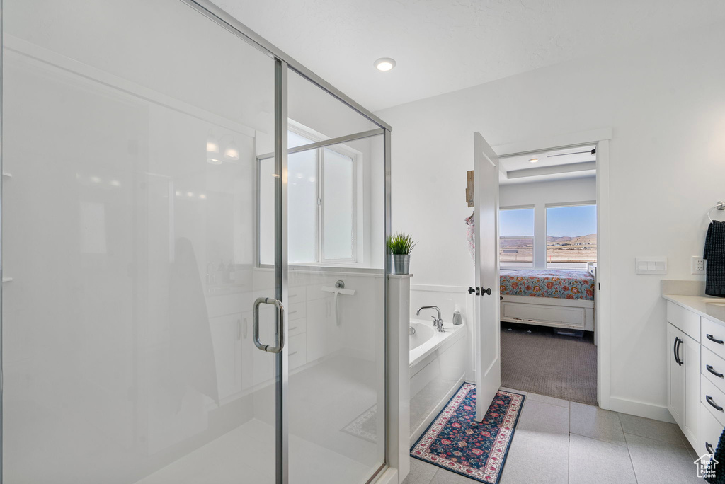 Ensuite bathroom featuring vanity, a bath, a stall shower, and tile patterned flooring