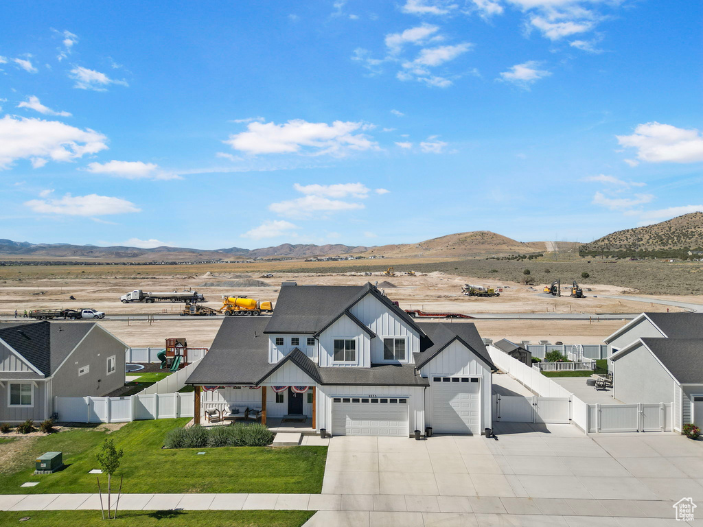 Modern farmhouse featuring a gate, board and batten siding, driveway, a mountain view, and covered porch