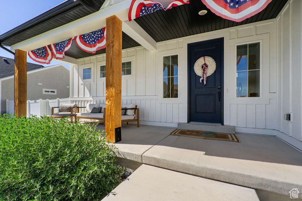 Doorway to property featuring board and batten siding and covered porch