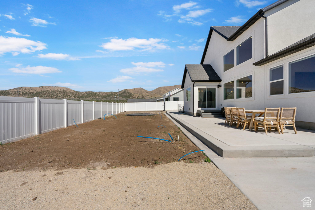 Fenced backyard with a mountain view and a patio area