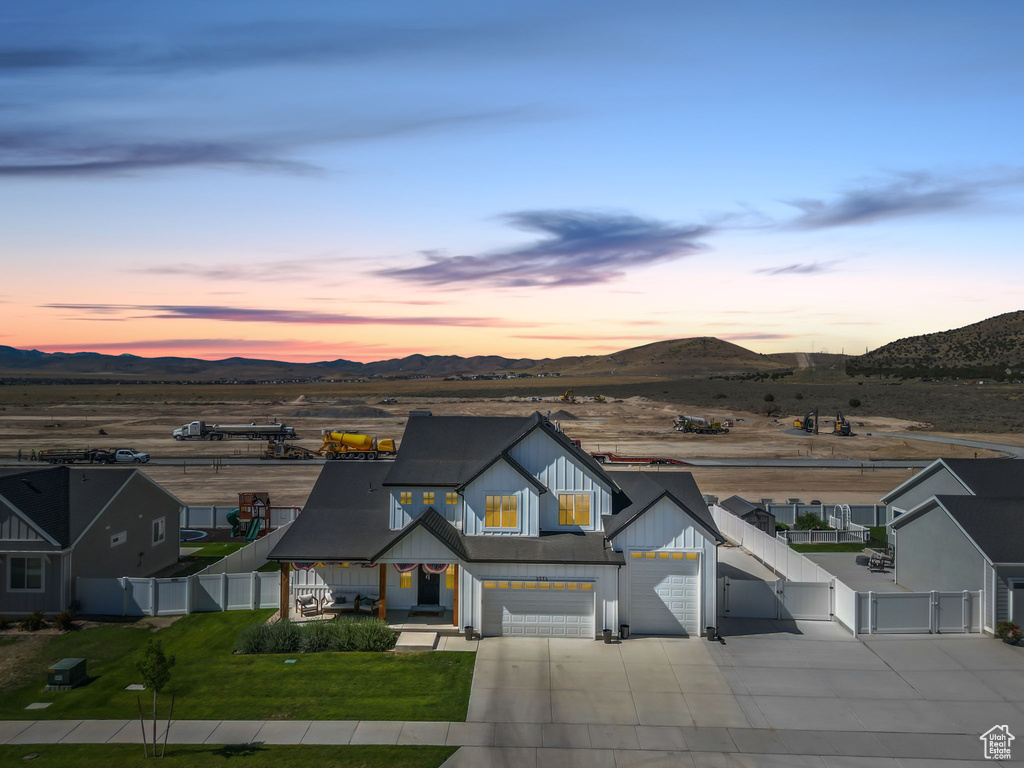 Modern farmhouse style home with a gate, concrete driveway, a fenced backyard, and a mountain view