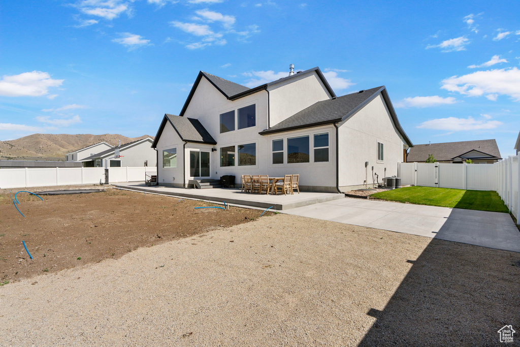 Back of property with a fenced backyard, a patio area, stucco siding, and a gate