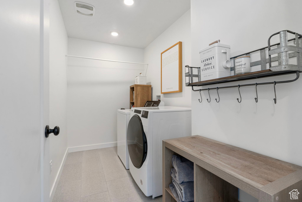 Laundry room featuring independent washer and dryer, recessed lighting, and cabinet space