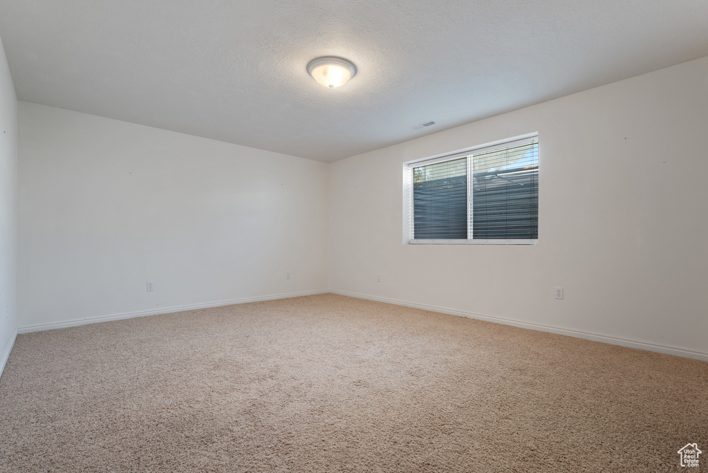 Empty room featuring carpet flooring and baseboards