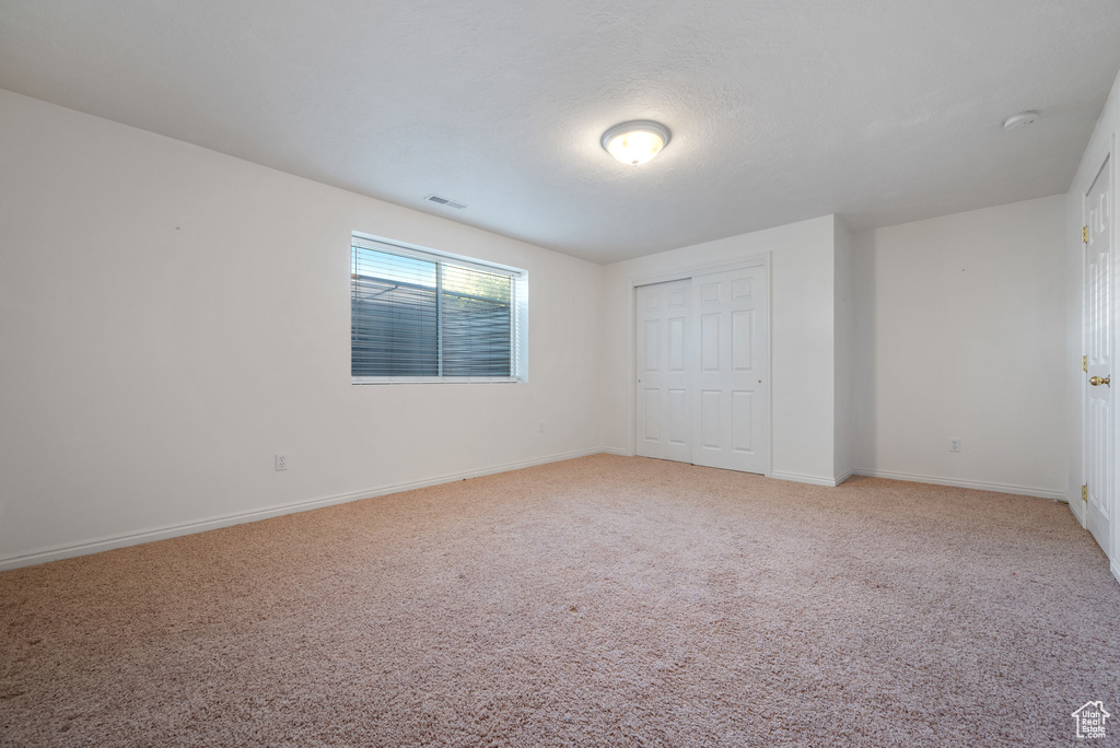 Unfurnished bedroom featuring light colored carpet and a closet