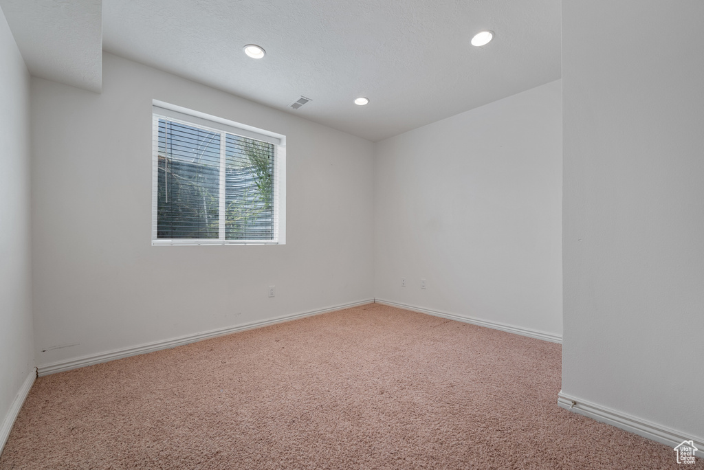 Carpeted empty room with recessed lighting and baseboards
