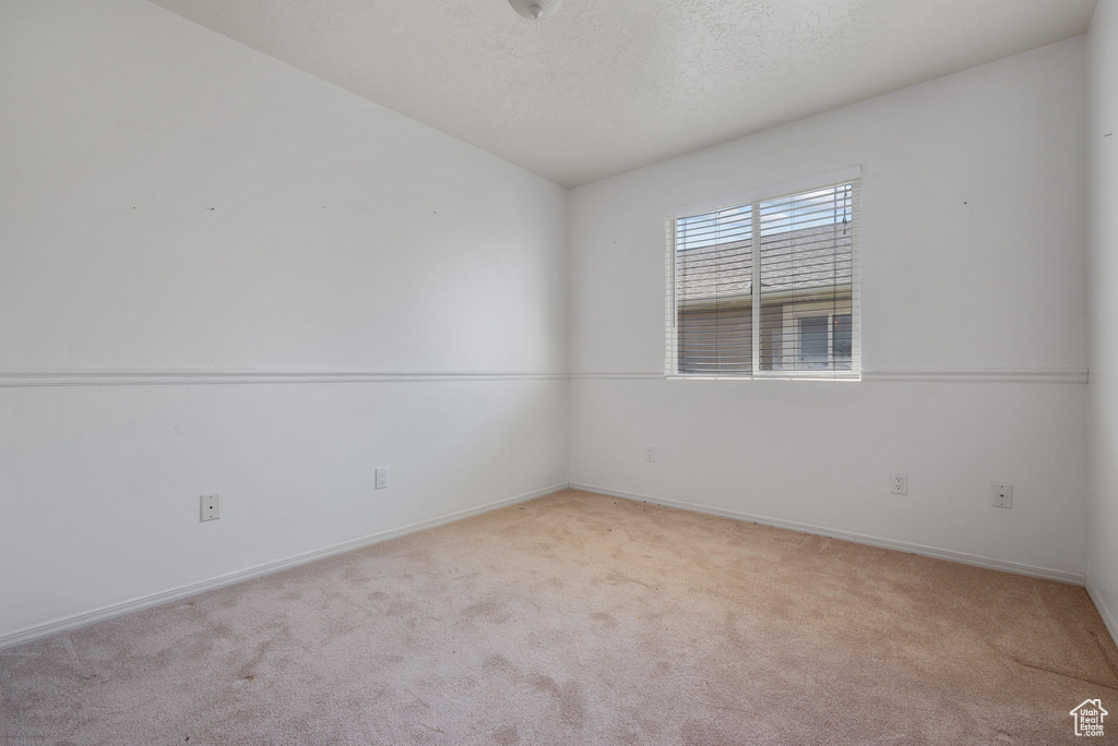 Carpeted spare room with baseboards