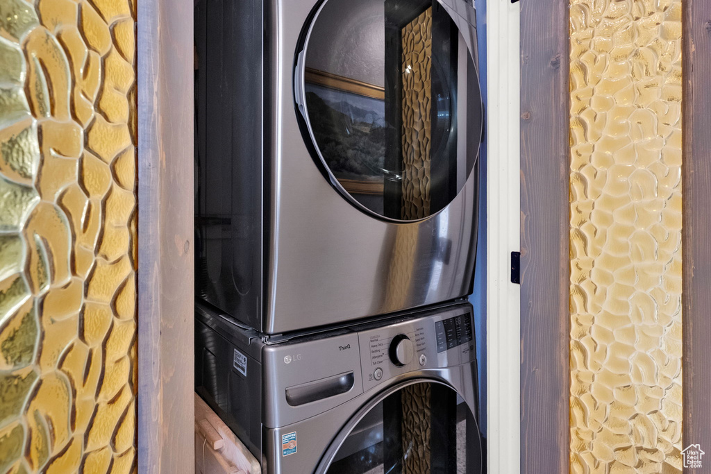 Laundry room with stacked washing machine and dryer