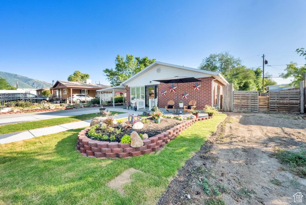 Rear view of house featuring brick siding, driveway, and a carport