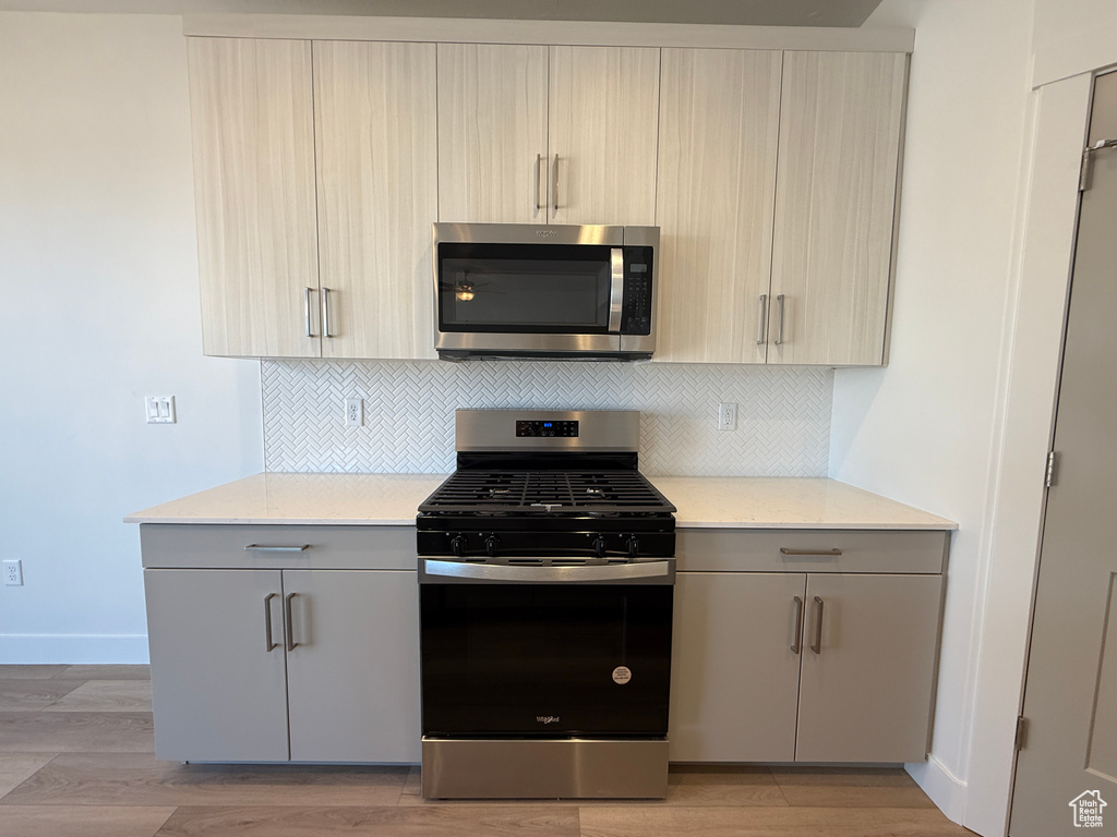 Kitchen with appliances with stainless steel finishes, modern cabinets, and tasteful backsplash